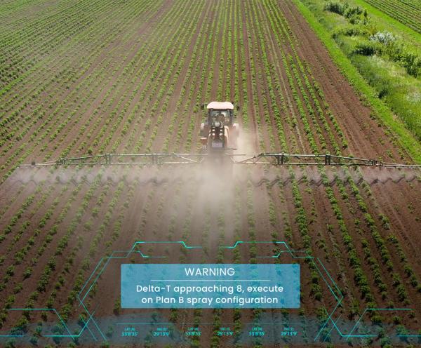A tractor and spray boom spraying a cotton paddock.